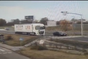 Na zdjęciu widzimy jak samochód osobowy wyprzedza samochód ciężarowy na przejściu dla pieszych