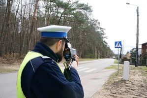 Na zdjęciu widzimy policjanta w czasie mierzenia prędkości